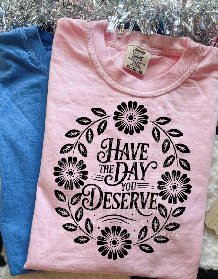 Pink t-shirt with floral design and text on a hanger