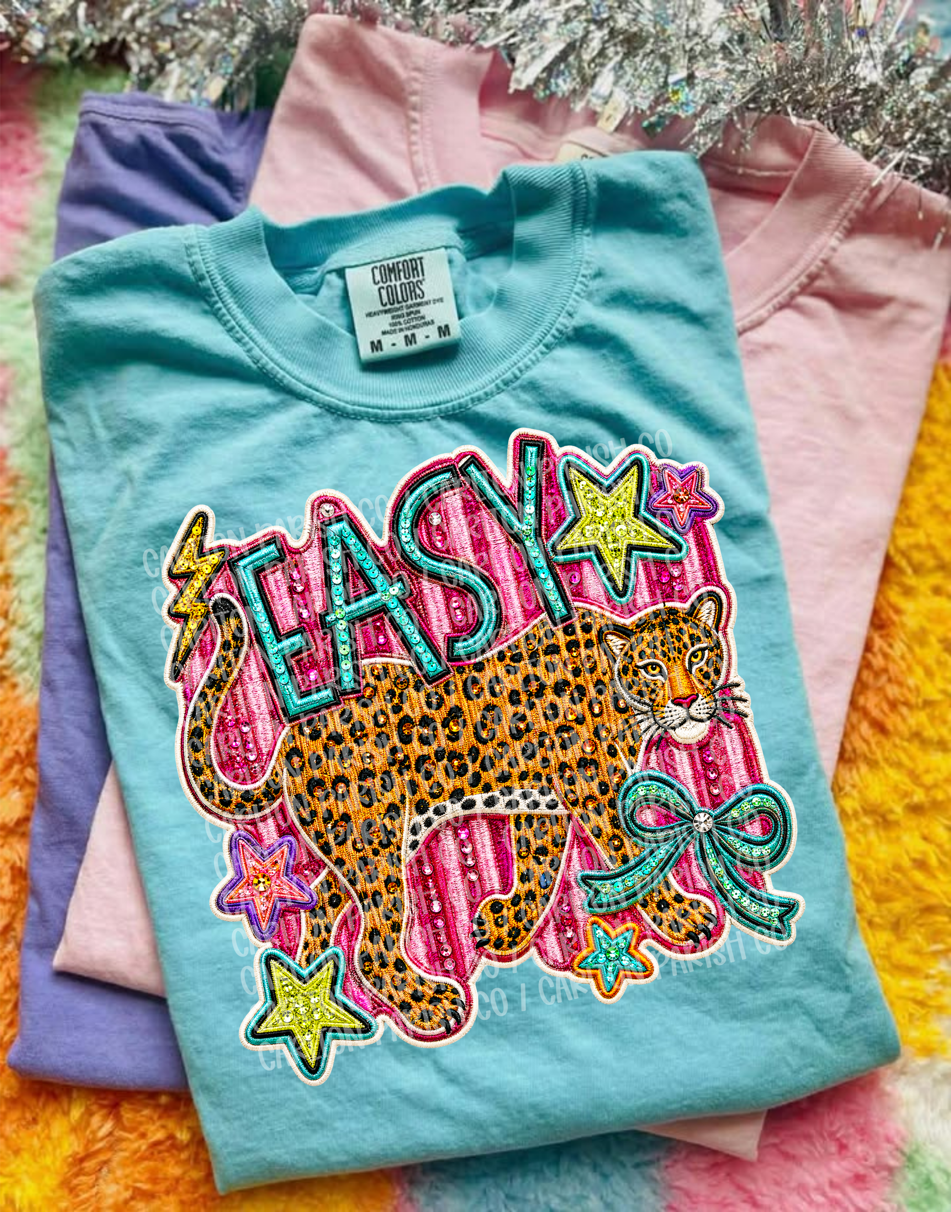 Colorful t-shirt with a leopard design and 'EASY' text on a multicolored fabric background