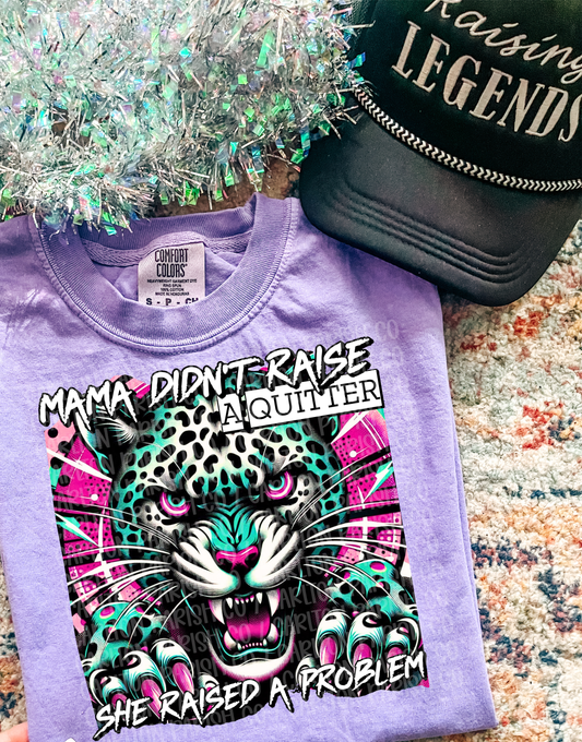 Purple t-shirt with a graphic design and text, placed on a textured surface.