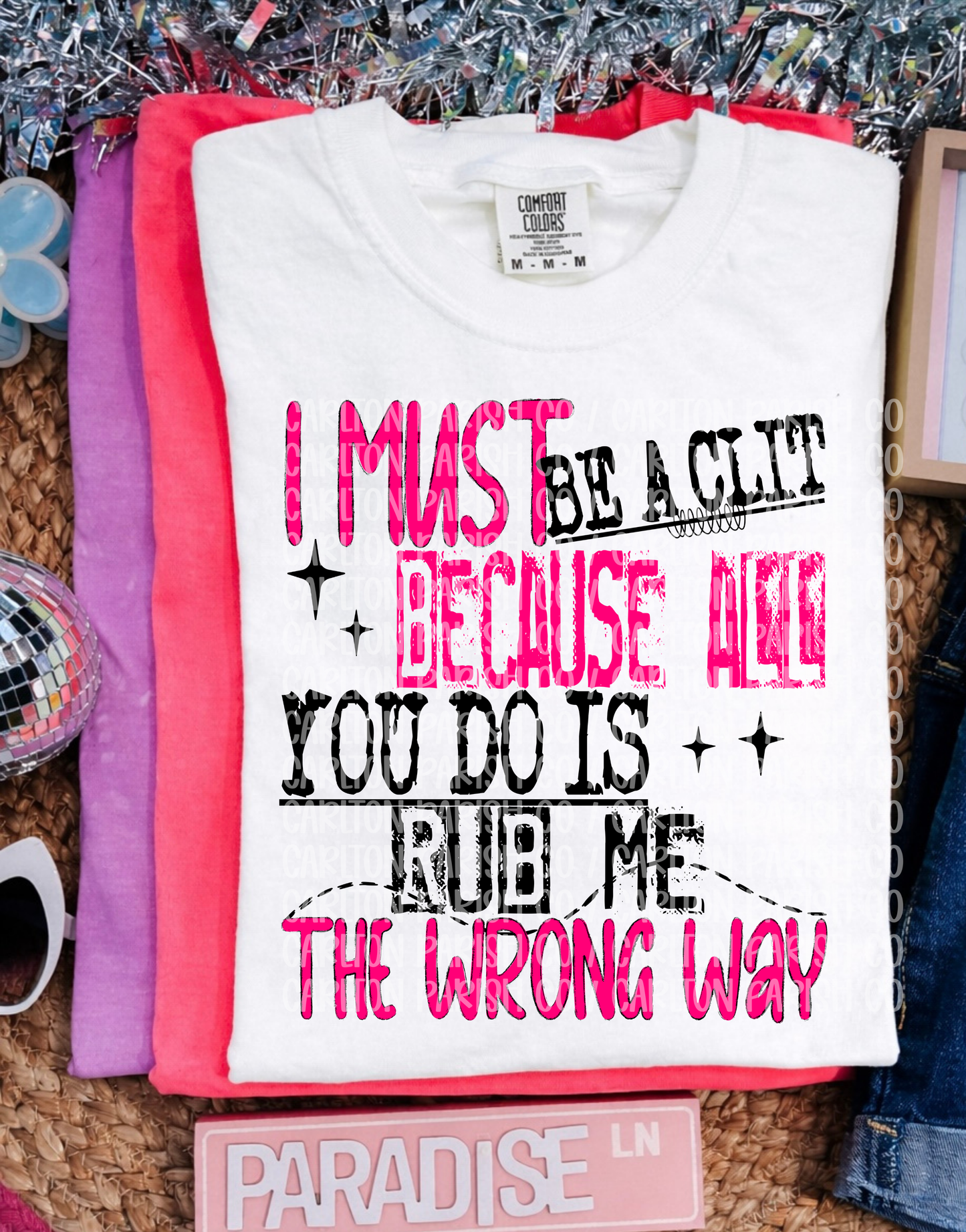 White t-shirt with humorous text design on a textured surface.